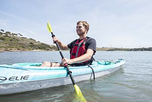 Man kayaking on a lake with a blue kayak and yellow paddle.